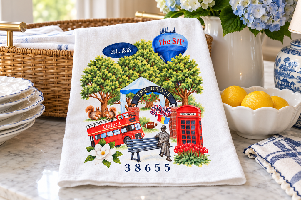 A Love Letter to Oxford flour sack tea towel folded on a marble counter with lemons and blue and white china