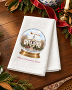 Merry Christmas, Y'all! snow globe tea towel styled in a holiday scene, showing the Oxford courthouse inside a snow globe with Santa's sleigh and a red truck.
